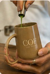 Matcha being poured into a COF mug